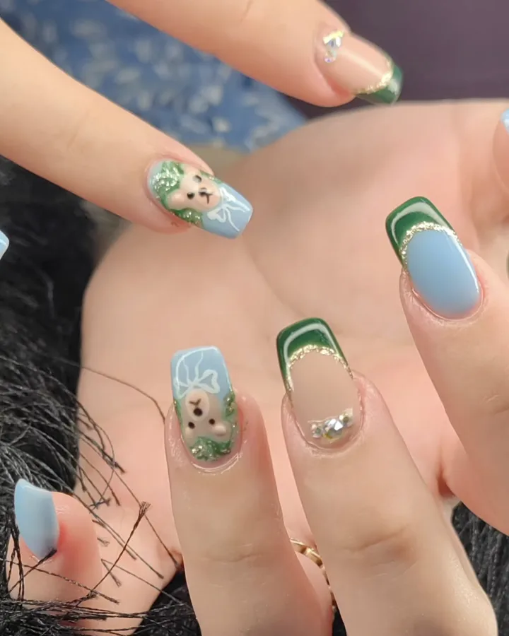 Nail art vert et bleu avec motifs peints à la main